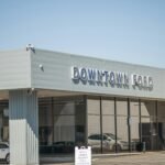 A car dealership with cars parked in front of it